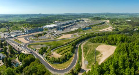 Un grand circuit entouré de collines verdoyantes. On aperçoit en arrière-plan les tribunes et les stands.