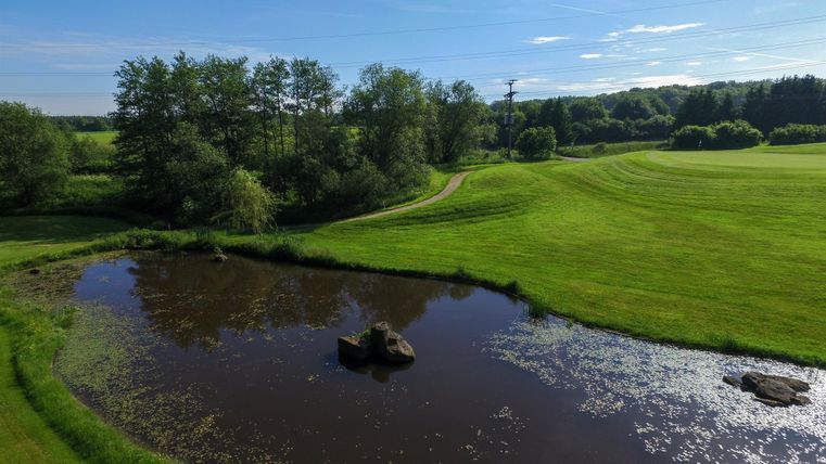 View of golf course with pond