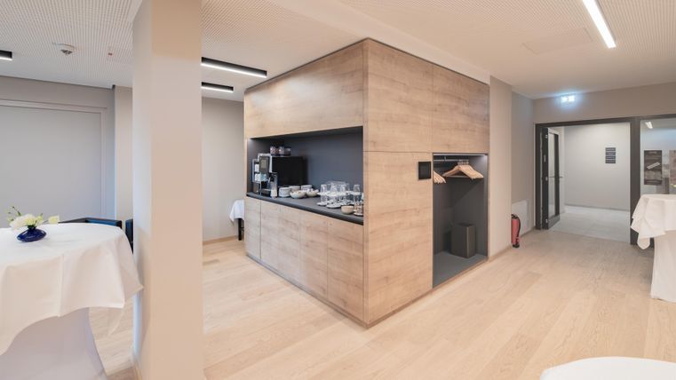 Een moderne binnenaanzicht met een open ruimte. In het midden bevindt zich een op maat gemaakte keukeneiland van hout.