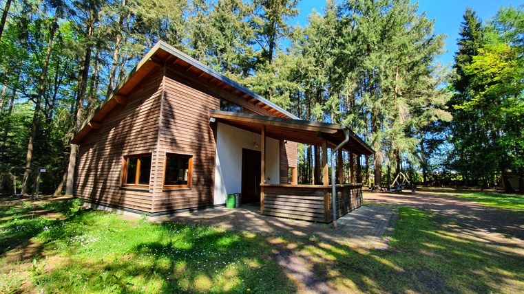 Holzhütte im Wald mit blauen Himmel.