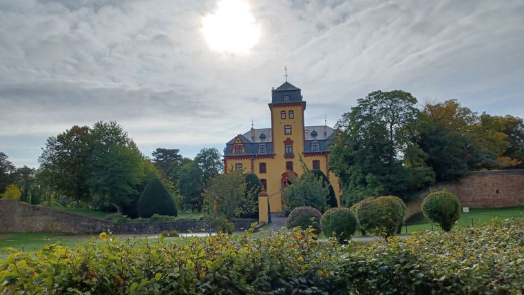 Kasteel Wachendorf met tuin op de voorgrond en bewolkte lucht.