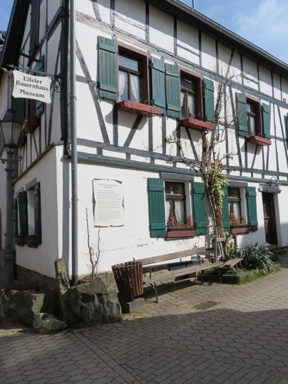 Ein traditionelles Fachwerkhaus mit grünen Fensterläden. Der Eingangsbereich ist einladend und spiegelt die charmante Architektur wider.