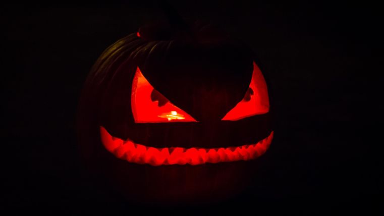Citrouille avec des yeux et une bouche rougeoyants