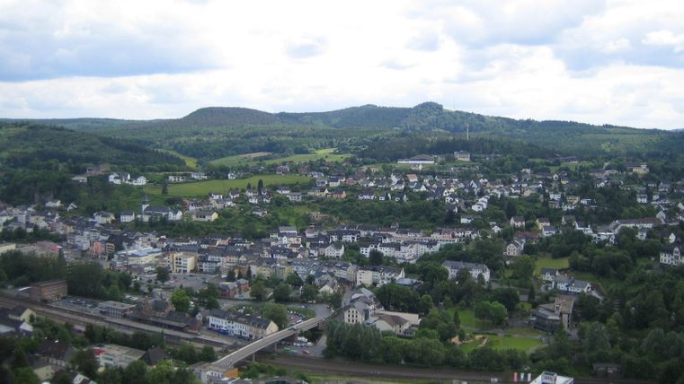 Panoramisch uitzicht op Gerolstein vanaf de Munterley met groene heuvels op de achtergrond.