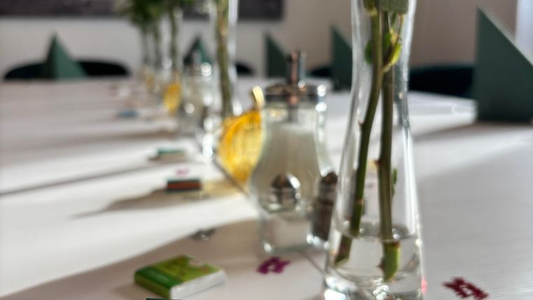 A festively set table with several flower vases and a card that says: "TODAY IS ALL ABOUT YOU DAY." The atmosphere feels inviting and friendly.