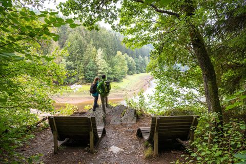 2 people are looking at the dammed Perlenbach