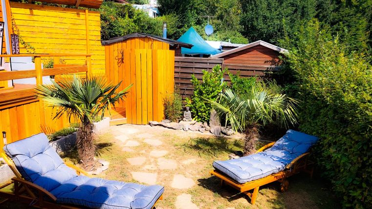Jardin de sauna ! Réserve ta sauna via notre application pour les invités du Camping Hetzingen et profite de ton séjour dans le jardin après ta séance de sauna. Un joli jardin avec des chaises longues et des palmiers. La construction en bois et le contexte verdoyant créent une atmosphère détendue.