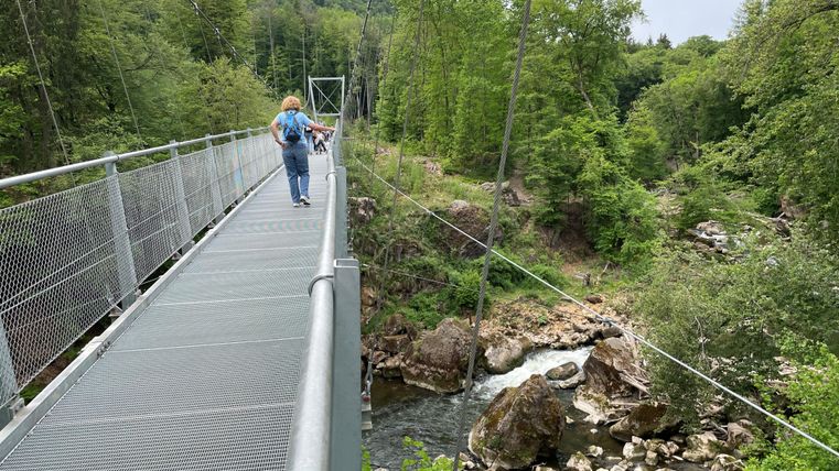 Eine Frau überquert die Hängebrücke über die Irreler Wasserfälle.