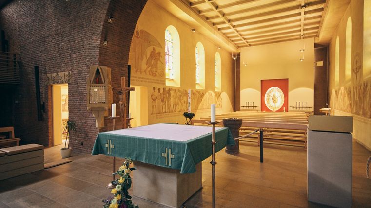 Blick durch das Kirchenschiff einer Kirche. Im Vordergrund befindet sich der Altarraum.